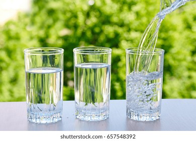 Three Glasses Of Water On A Natural Background.