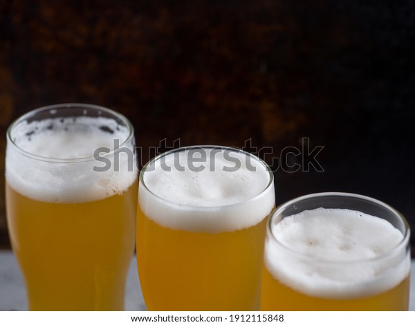 three glasses of wheat\
beer on the table