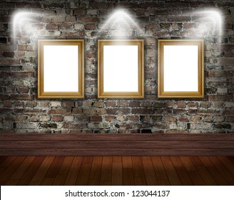 Three gold frames on brick wall in grunge room