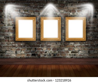Three gold frames on brick wall in grunge room