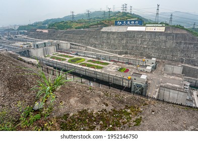 Three Gorges Dam, China - May 6, 2010: Yangtze River. Long View On Half Of Locks Of Ship Lift Under Foggy Morning Sky. Green Hills  Above. Flower Beds Add Color.