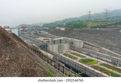 Three Gorges Dam, China - May 6, 2010: Yangtze River. View On Half Of Locks Of Ship Lift Under Foggy Morning Sky. Green Hills Above. Flower Beds Add Color.