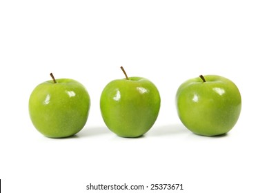Three green apples in a row, casting natural shadow on white.