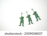 Three green plastic toy soldiers arranged in a playful line on a white background.