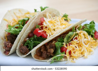 Three Ground Beef Tacos On A White Plate