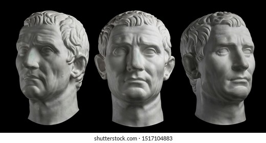 Three Gypsum Copy Of Ancient Statue Head Of Guy Julius Caesar Isolated On Black Background. Plaster Sculpture Man Face.