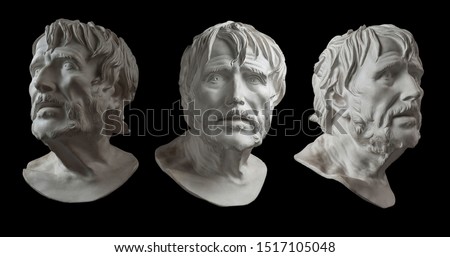 Three gypsum copy of ancient statue head of Lucius Seneca isolated on black background. Plaster sculpture aged man face.