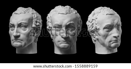 Three gypsum copy of ancient statue Gattamelata, Erasmo di Narni, head isolated on black background. Plaster sculpture man face.