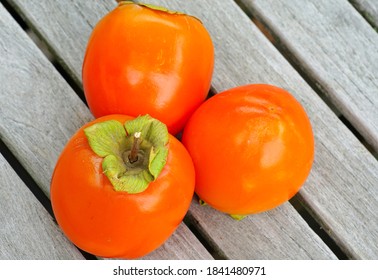 Three Hachiya orange persimmon kaki fruits