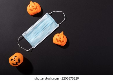 Three halloween pumpkin toys and face mask against grey background. halloween festivity and celebration during covid-19 pandemic concept - Powered by Shutterstock