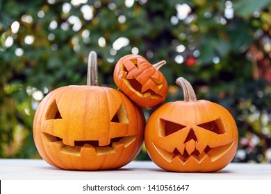 Three Halloween pumpkins or jack-o-lantern at home terrace. Decoration and holidays concept