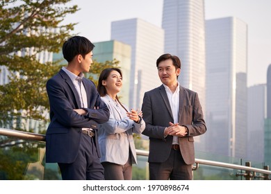 Three Happy Asian Businesspeople Chatting Talking Discussing Business Outdoors