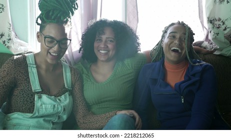 Three Happy Black Young Women Hanging Out Together Laughing And Smiling. Brazilian African American Friends At Home Living Room Couch. Real Life Laugh And Smile