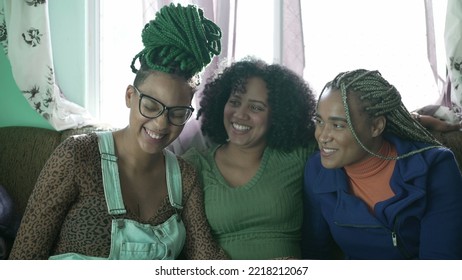 Three Happy Black Young Women Hanging Out Together Laughing And Smiling. Brazilian African American Friends At Home Living Room Couch. Real Life Laugh And Smile