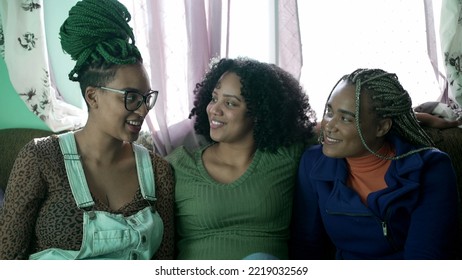 Three Happy Black Young Women Hanging Out Together Laughing And Smiling. Brazilian African American Friends At Home Living Room Couch. Real Life Laugh And Smile