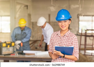 Three Happy Builders In Hardhat Works On The Building Site. Construction Manager And Engineer Working On Building Site. Constructor Work, Business Plan.