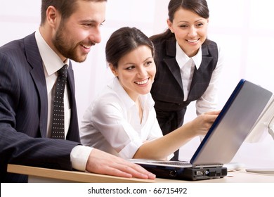 Three Happy Business People In A Meeting At Office