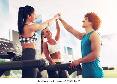 Three Happy Friends Having A Sports Greeting Afther Workout At The Gym. They Are Fist Bump With Smile On Their Face.