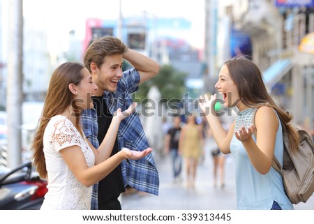 Three happy friends meeting in the sidewalk of a street of a big city with an urban background