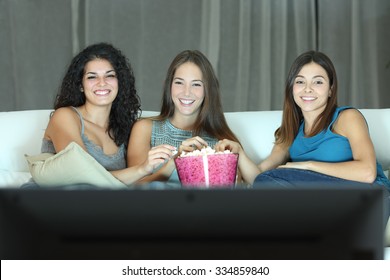 Three Happy Friends Watching Tv Sitting On A Couch At Home