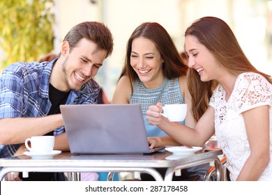 Three Happy Friends Watching Videos In A Laptop In A Coffee Shop Terrace Outdoors