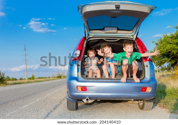 three happy kids in car, family trip, summer
vacation travel