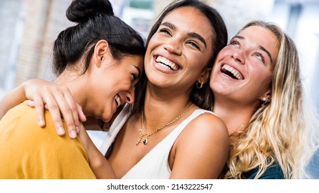 Three happy women smiling together outdoors - Multicultural girls having fun on city street - Happy friendship concept with females enjoying day out  - Shutterstock ID 2143222547