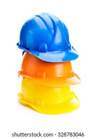 Three Hard Hats In Blue, Orange And Yellow Colors Piled Up Shot On White Background