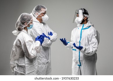 Three healthcare workers have informal meeting wearing in hazard on white background