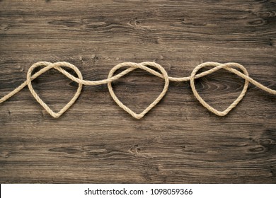 Three heart rope shapes  on old wood