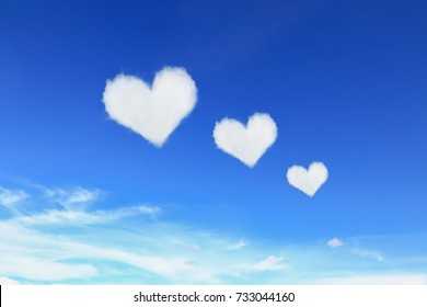 Three Heart Shaped Clouds On Blue Sky.