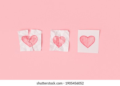 Three hearts drawn pieces paper pink background  One heart is torn  the second is crumpled  the third is whole  Progress love 