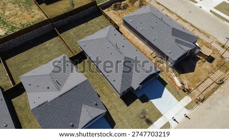 Three home alignment developing block at Highpointe Ranch, US 377, Blackjack Rd completed houses beside active yard and driveway work. Gray shingles, fresh lawns, raw soil textures, Aubrey, TX. USA