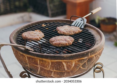 Three Homemade Hamburgers Grilling At Backyard Bbq