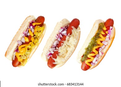 Three hot dogs with an assortment of toppings, top view isolated on a white background