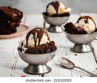 Three hot fudge brownie sundaes with vanilla ice cream