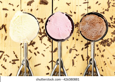 Three Ice Cream Scoops On Wooden Surface