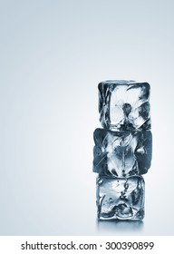 Three ice cubes stacked over blue gradient background with copy space