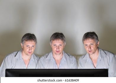 Three Identical Clones Or Triplets Watching Television Or A Computer Screen Together