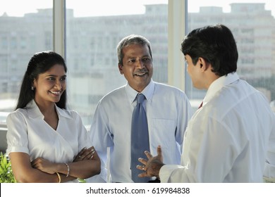 Three Indian people talking together and laughing