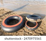 Three inner tubes on the beach. It help children to play in the water at the beach or swim