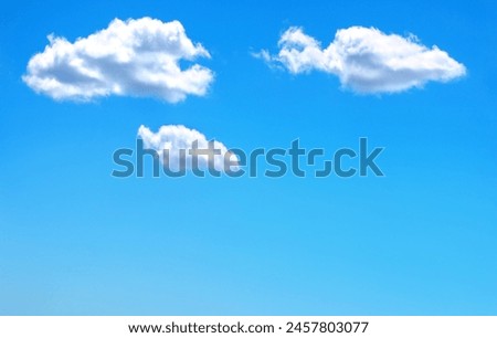 Three isolated white clouds in a clear blue sky with space for text.