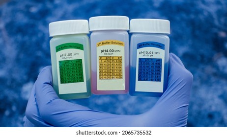 Three jars of colored solutions for an acidity meter. Various solutions for analysis in the laboratory.