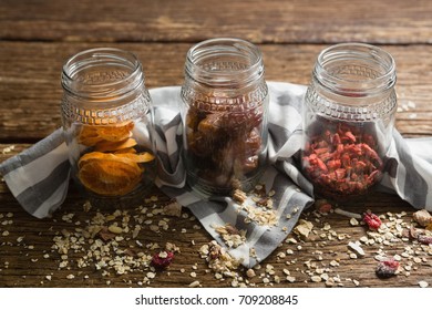 Three jars with various breakfast on wooden table