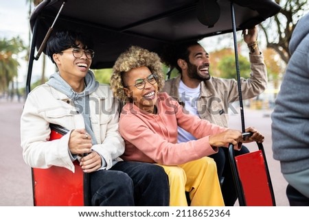 Three joyful diverse tourist friends riding in tuk tuk taxi on vacation in Barcelona - Multiracial friends laughing and having fun visiting an european city on holidays