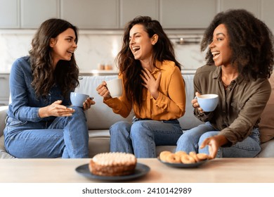 Three joyful multicultural women friends share a cozy moment over coffee and cake, celebrating their friendship in the modern kitchen. Warm moments of true female friendship - Powered by Shutterstock