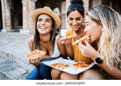 Three joyful multiracial women having fun eating pizza during summer vacation in Italy. Summer time and vacation lifestyle concept. - Powered by Shutterstock