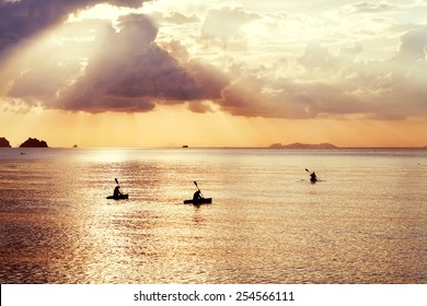 Three Kayak Float At Sunset