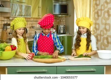 Three Kids Cooking, Vegetables. Children In Chef Uniforms. Things Every Cook Should Know.