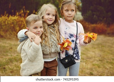 Three Kids Having Fun In Autumn Park